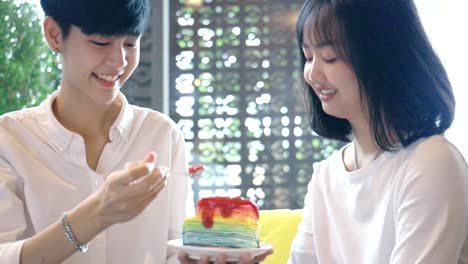 Young-Asian-Lesbian-Couple-Feeding-Sweet-Rainbow-Cake,-LGBT-Love-Moment-Slow-motion