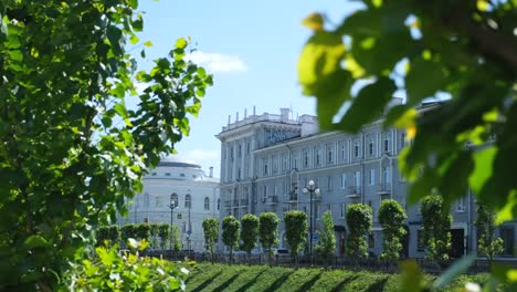 Close-up-view-of-green-leaves-with-Chernoyarovsky-Passage,-on-the-background-in-summer-day.-Stock-footage.-Kazan-city,-Tatarstan-republic,-Kremlevskaya-street