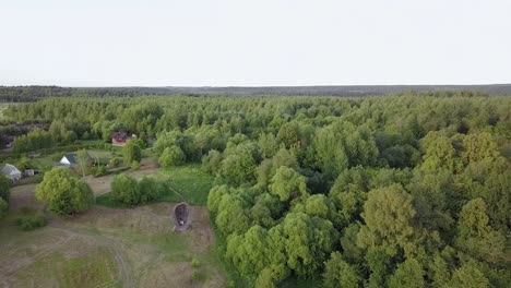 Aerial-view-of-the-Russian-forest,-river-and-steppe-overlooking-an-abandoned-Church-and-architectural-objects