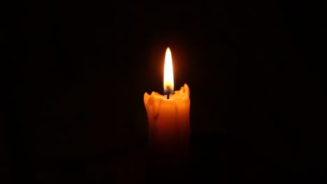 Closeup-of-candle-flame-on-black.-Old-white-candle