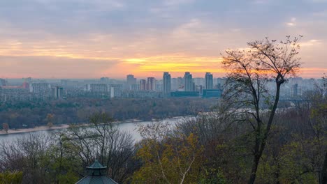 Panorama-de-la-ciudad-de-Kiev-y-el-río-Dnipro-al-amanecer,-vista-panorámica-al-colorido-paisaje-urbano-de-otoño-por-la-mañana,-Ucrania-4k-lapso-de-tiempo