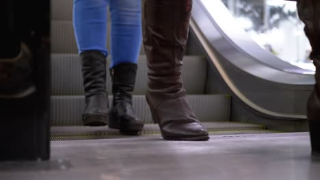 People's-Feet-go-Down-the-Escalator-Lift-in-the-Mall.-Shopper's-Feet-on-Escalator-in-Shopping-Center