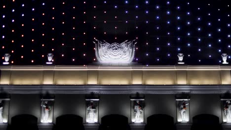 Bright-illuminated-facade-of-the-soviet-building-at-night-with-the-Hammer-and-Sickle-symbol.-Stock-footage.-Beautiful-house-exterior-decorated-with-flashing-lights