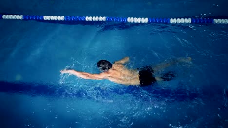 Vista-superior-de-un-nadador-masculino-con-una-pierna-protésica-en-una-piscina