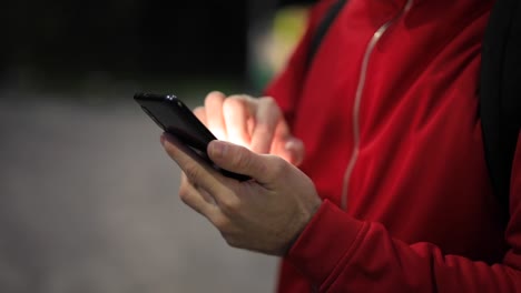 Nicht-wiedererkennbare-Person-mit-Smartphone-im-Park