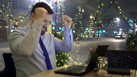 Erfolgreicher-Geschäftsmann-bekommt-gute-Nachricht-am-Laptop,-glücklich,-Café-Abend,-Dolly-Schuss