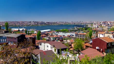 Panoramic-top-view-with-red-roofs-of-houses-and-mosques-behind-Golden-Horn-timelapse-in-Istanbul,-Turkey