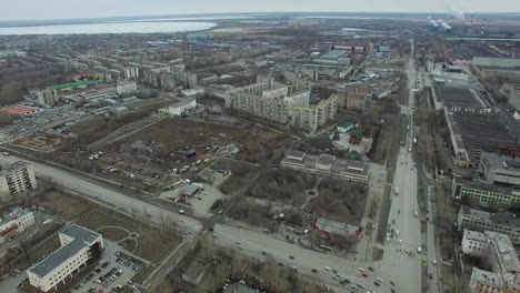 Luftaufnahme-zur-Stadt.-Blick-vom-Himmel-auf-die-russische-Stadt.-Blick-in-die-Stadt.-Der-graue-Himmel-und-die-Garagen-sind-wirklich-ein-Wohnviertel.-Luftdurchsuchung-auf-der-Straße,-wo-viel-Auto-fahren.-Tscheljabinsk.-Ural.-Überleitung-von-Luftflug