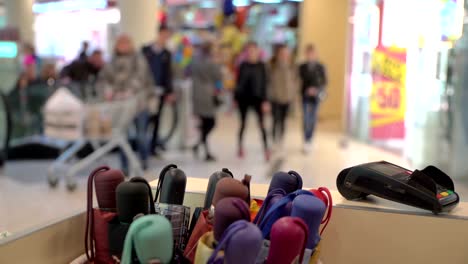 Concept-contactless-payment-by-credit-card-in-supermarket.-Pos-terminal-on-counter-near-umbrellas