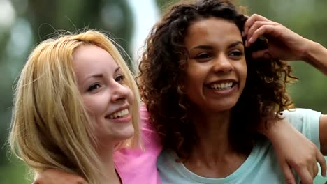 Gay-female-couple-smiling,-embracing-tightly-while-posing-in-front-of-camera