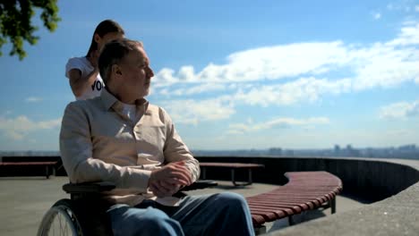 Wheelchaired-aged-man-talking-with-a-female-volunteer