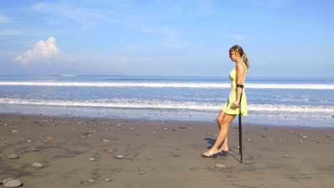 CLOSE-UP-Frau-mit-Krücken-zu-Fuß-entlang-der-plätschernden-Meer-auf-sonnigen-Bali