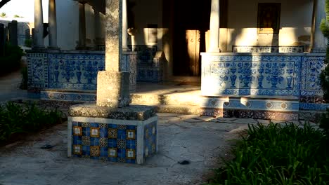 Stone-cross-standing-front-of-small-old-chapel-in-Portugal,-travel-destination