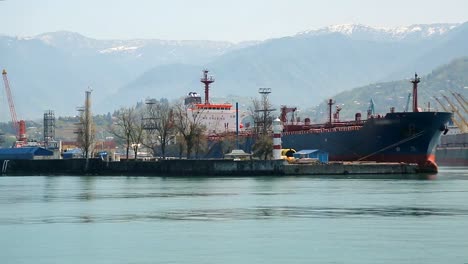 Puerto-de-la-ciudad-con-espectaculares-montañas-en-el-fondo,-el-transporte-comercial