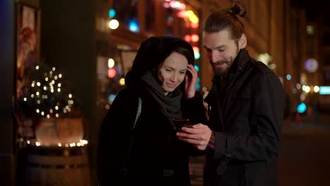 Young-happy-couple-using-smartphone-at-night.