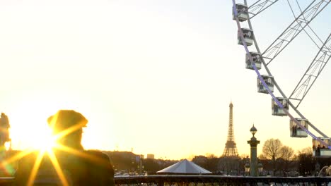 Turistas-observando-la-puesta-de-sol-desde-la-noria,-la-Torre-Eiffel-en-el-fondo-de-rotación