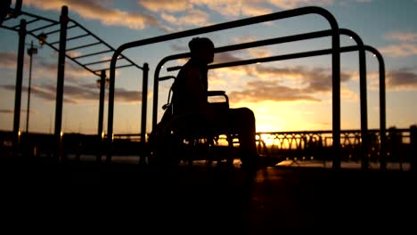 Hombre-discapacitado-contratado-en-las-barras-en-el-atardecer-de-verano