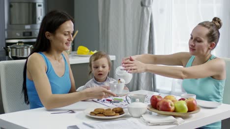 Madres-con-niños-pequeños-tomar-té-en-la-cocina