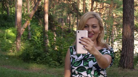 Wunderschöne-lächelnde-Frau-mit-video-Chat-mit-Telefon-im-park