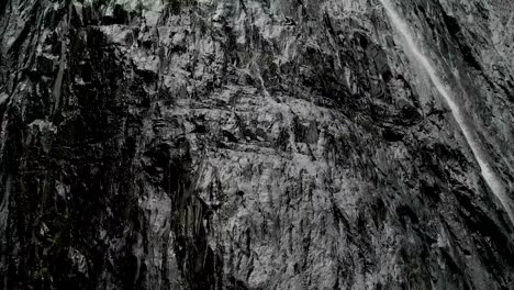 Tracking-and-top-shot-Air-shot-from-a-stream-of-water-splashing-waterfall-on-a-rock-wall-in-the-Caucasus-Mountains.-Around-the-jet-of-the-waterfall