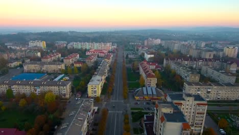 Luftaufnahme-von-Drohne:-Stadt-mit-einer-Straße-und-Autos,-Häuser-und-Parkplätze.