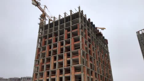 Construction-of-a-high-rise-apartment-house.-The-construction-crane-works-at-the-construction-site