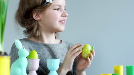 Girl-paints-Easter-eggs-with-her-fingers