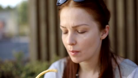 beautiful-young-Caucasian-woman-sitting-after-work-in-the-evening-in-a-street-cafe-drinking-coffee-and-chatting-on-social-networks-using-a-smartphone.