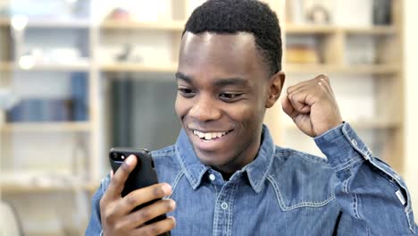 Excited-Happy-African-Man-Using-Smartphone