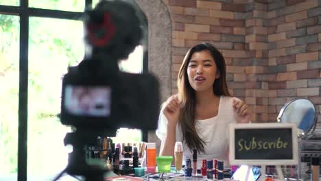 Asian-woman-recording-video-about-cosmetics-with-DSLR-on-tripod