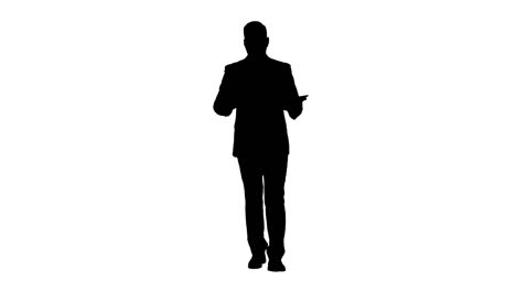 Silhouette-Businessman-swiping-pages-on-a-tablet-and-talking-to-camera-explaining-something-while-walking