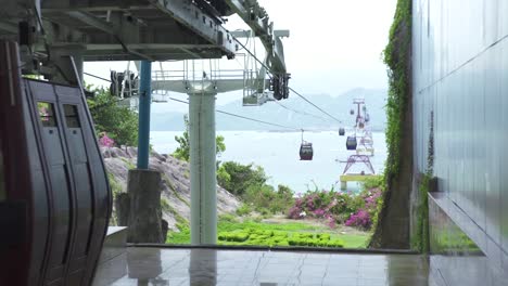 Cable-car-cabins-moving-on-rope-way-for-passenger-transportation-across-sea-in-modern-city.-Cable-way-with-car-cabins-between-island-in-sea