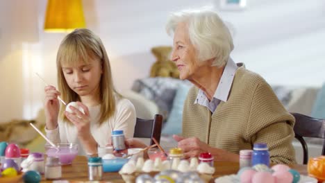 Grandmother-Watching-Granddaughter-Paint-Eggs