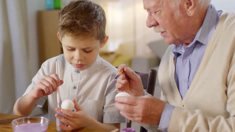 Grandfather-Teaching-Grandson-to-Paint-Eggs