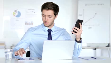 Empresario-multitarea-usando-smartphone,-Tablet-y-Laptop-en-el-trabajo