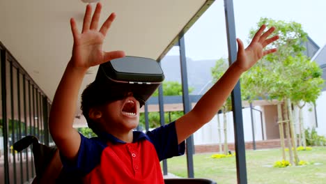 Front-view-of-disabled-African-American-schoolboy-using-virtual-reality-headset-in-school-corridor-4