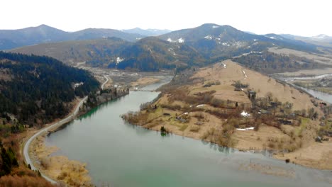 Bergsee-bei-bewölktem-Wetter-von-der-Drohne-entfernt-Schöne-Herbstlandschaft-mit-Wald-und-Bergen.