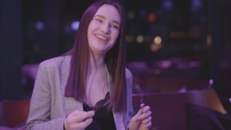 Cute-young-woman-eating-meat-grilled-with-vegetable-in-the-modern-restaurant.