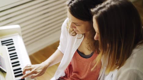 Girlfriends-learning-piano-playing-at-home