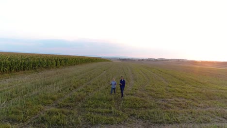 Dos-jóvenes-agricultores-modernos-caminando-sobre-el-campo