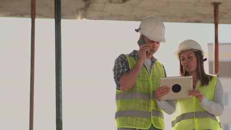 El-controlador-es-un-hombre-de-un-edificio-en-construcción-hablando-por-teléfono-con-la-administración-y-ha-discutido-con-el-ingeniero-y-arquitecto-mujer-progreso-de-la-construcción