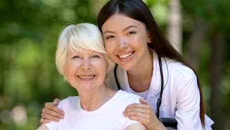 Amable-médico-abrazando-y-apoyando-a-pacientes-maduros-discapacitados,-personal-de-la-clínica-que-cuida