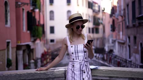 Slow-motion-de-feliz-excitada-chica-hipster-viendo-efecto-divertido-en-línea-a-través-de-la-aplicación-móvil-mientras-descansa-en-el-puente-italiano-durante-las-vacaciones-Europa