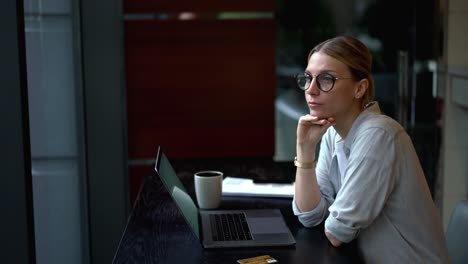 Pensive-woman-thinking-on-idea-while-working-remotely-on-digital-netbook-connected-to-wireless-internet