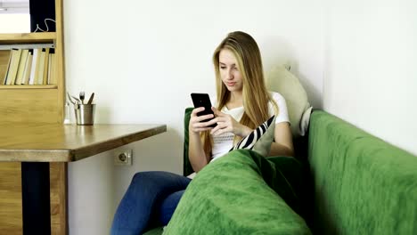 Attractive-young-happy-woman-using-mobile-phone-during-resting-in-a-cafe.-4K