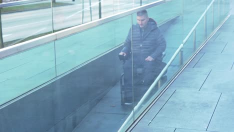 Man-on-electrical-wheelchair-using-a-ramp---Pan-follow-movement