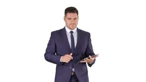 Businessman-walking-and-swiping-pages-on-his-tablet-computer-and-looking-to-camera-presenting-something-on-white-background