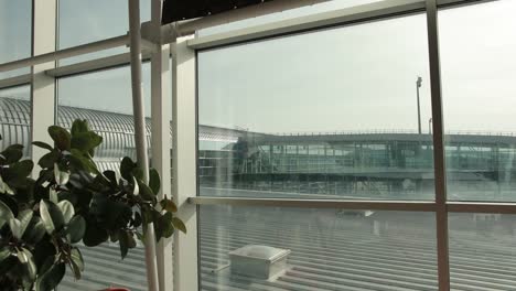 View-on-roof,-floodlight,-bright-sun-from-glass-airport-terminal-window.