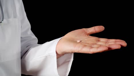 Close-up-pill-on-male-hand-palm-isolated-on-black-background.-Doctor-hands-holding-tablet-drug-compressing-on-palm-hands-on-dark-background.