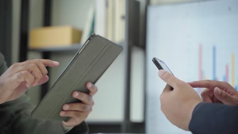 Two-businessman-using-smartphone-and-tablet-in-the-office.4K-Resolution.